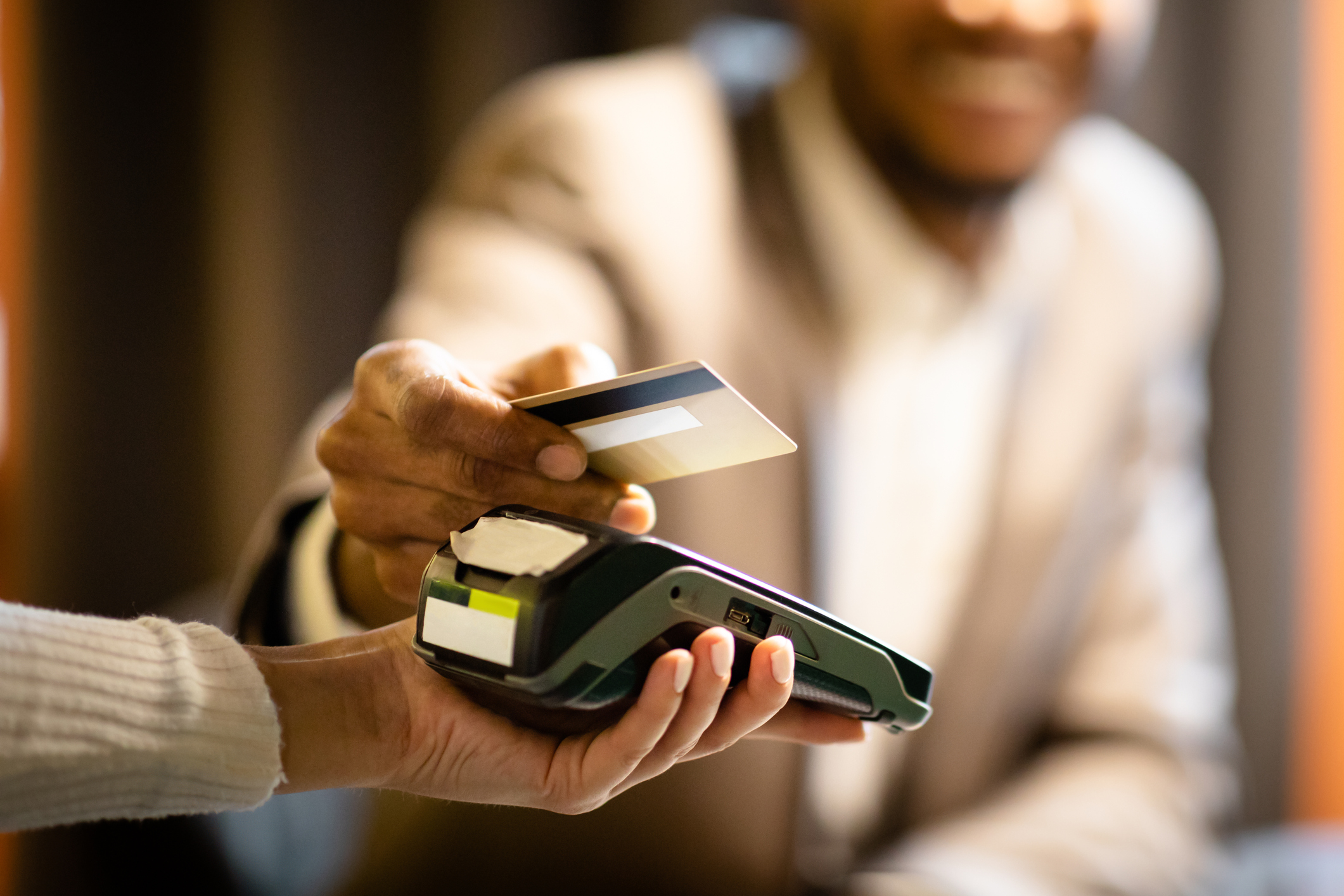 Afro businessman giving credit card to barman Afro businessman giving credit card to barman